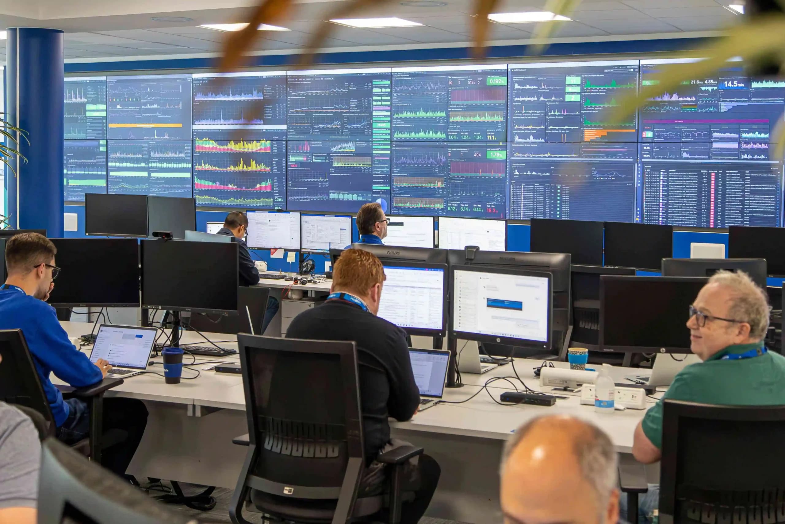 Technology engineers at Procode developing smart metering solutions across multiple computer screens in their smart lab.