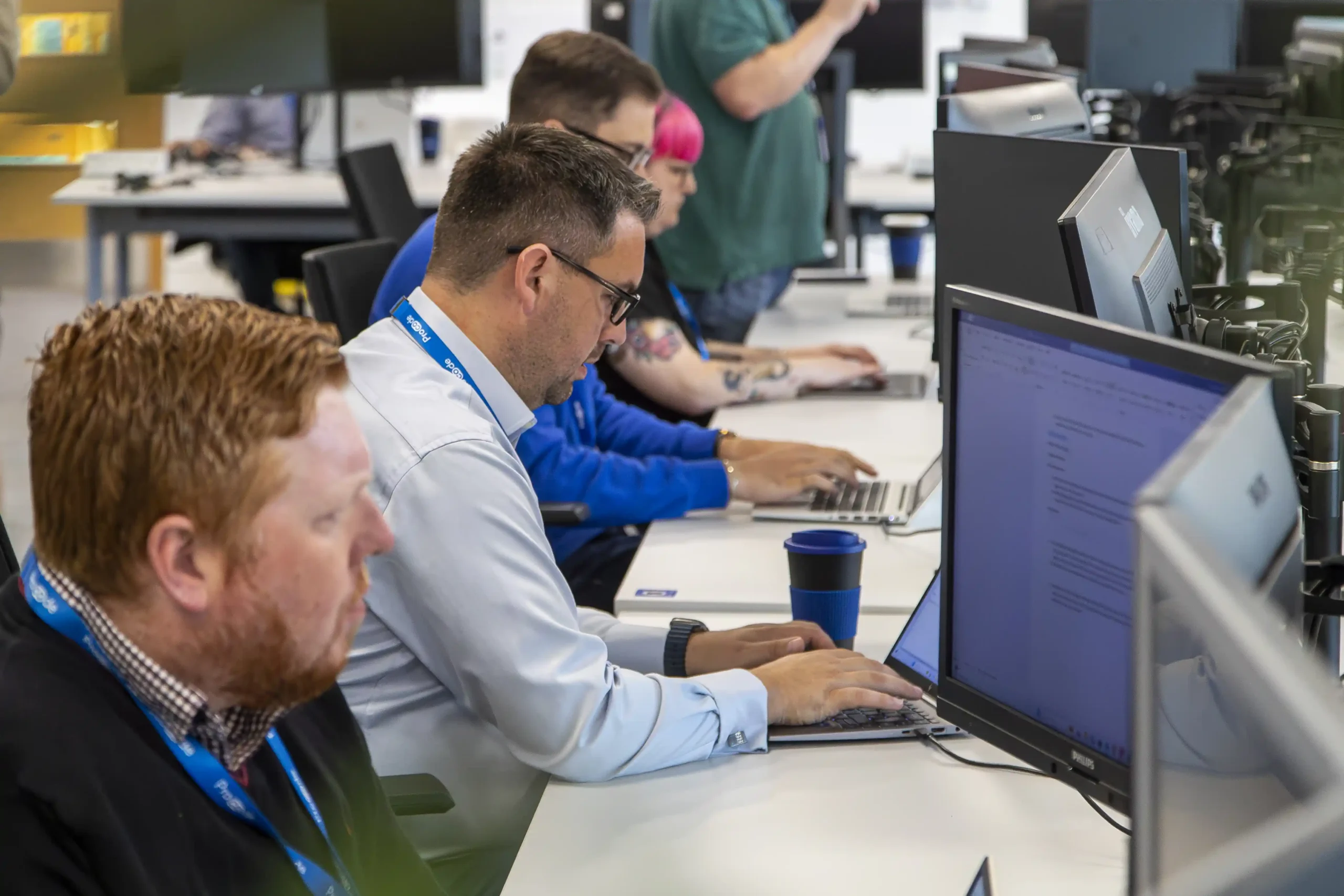 Procode engineers working on desktop computers, delivering data-driven smart metering solutions for businesses.